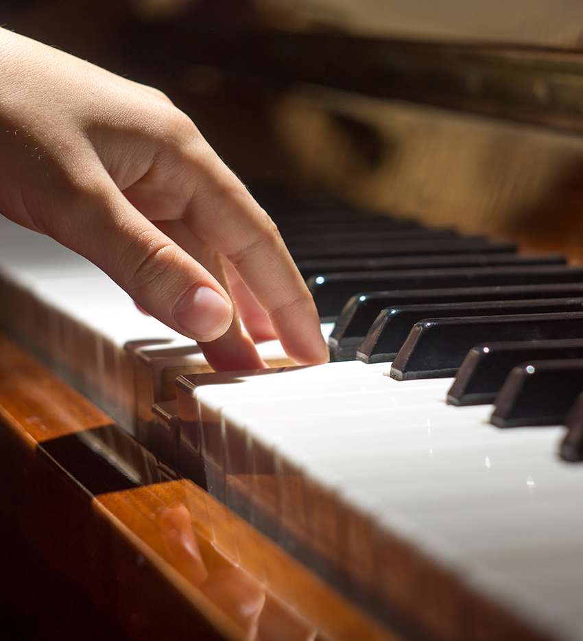 Little girl Playing on piano keyboard. Selective focus
